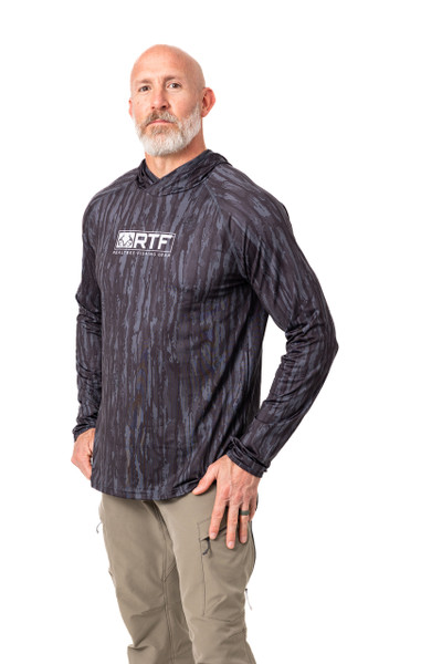 A close three-quarter front view of the Realtree Fishing Men's Hooded Black Shirt highlights the chest logo and textured camo print main.