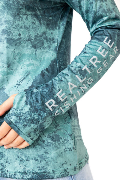 Close-up of the sleeve on the Realtree Fishing Women’s XTREME Emerald Green Hooded Shirt, featuring the "Realtree Fishing Gear" logo and thumbhole detail.