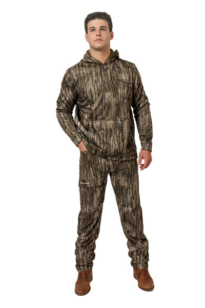 Man wearing Realtree Legacy camo hoodie and slim-cut hunting pants, standing with hands in pockets.