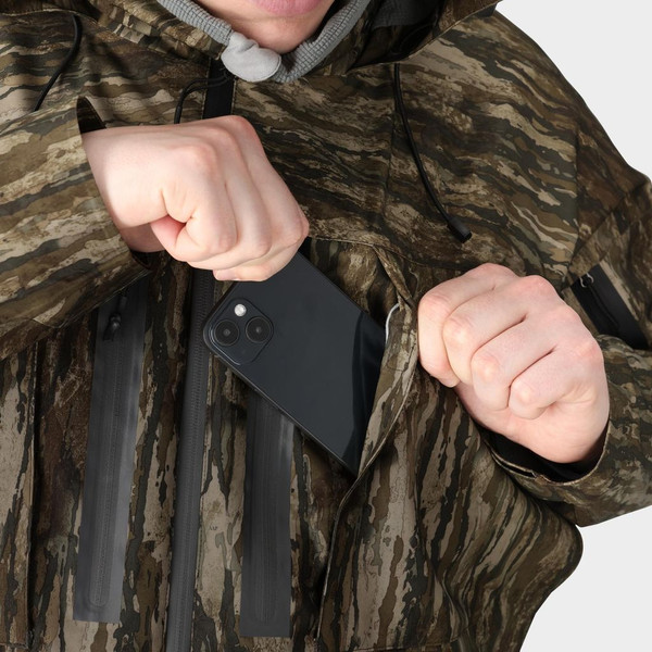 Close-up of zippered chest pocket on Frogg Toggs Oxbow Realtree Legacy camo jacket holding a smartphone.