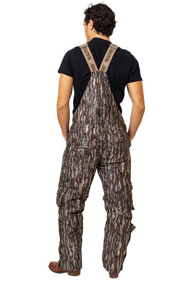 Back view of the hunting bibs showing the camo pattern, rear pockets, and adjustable Realtree-branded suspenders.