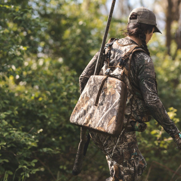 Rear view of hunter wearing DSG turkey vest with large back pouch and seat cushion attached.