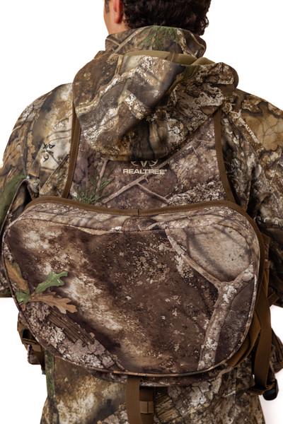 Front view of model holding shoulder straps of Spring Thunder Turkey Vest in Realtree APX.