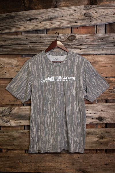 40th Anniversary Long Live Real tri-blend camo T-shirt hanging against wood backdrop main.