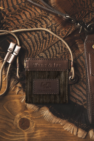 Wren & Ivy Realtree 40th Anniversary Call Pouch displayed on turkey feathers with premium leather and camo fabric main