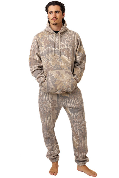 Man wearing Realtree Xtra Grey camo hoodie and matching sweatpants in a faded woodland bark pattern.