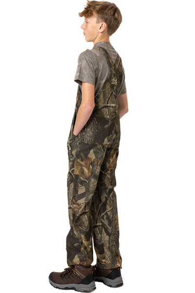 Rear angled view of Realtree Hardwoods bib overalls showing full coverage and strap design.