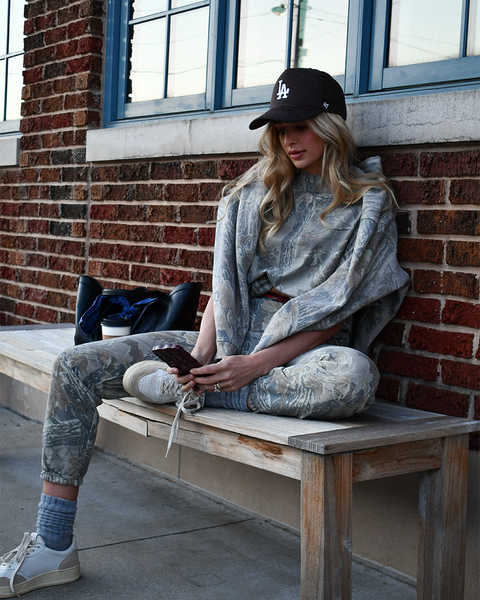 Woman wearing Banded Realtree Xtra Grey camo sweats sitting casually outdoors main