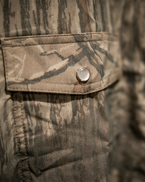 Detailed view of camo fabric and pocket stitching on Banded Trailhead shirt.