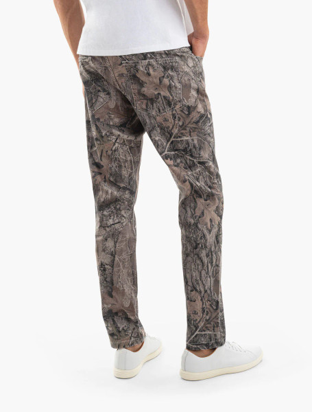 Back view of Mugsy men's Realtree EDGE camo denim jeans worn by model.