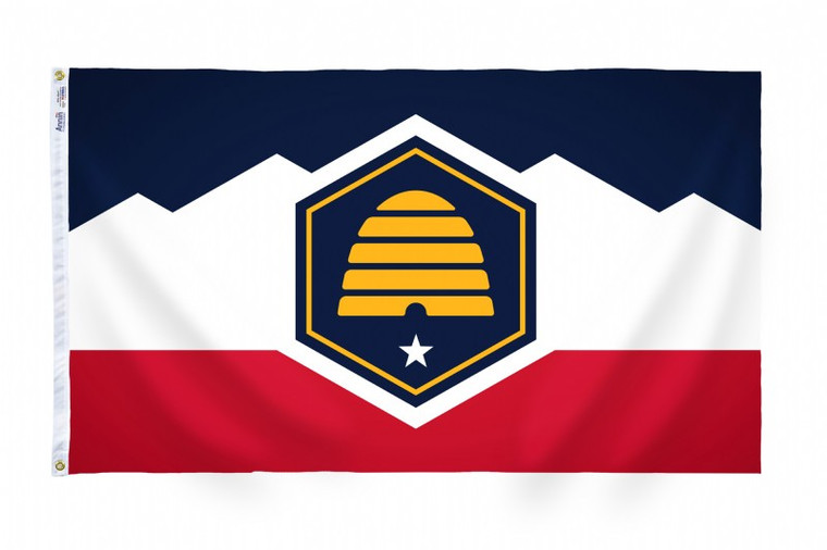 The Utah flag, measuring 3 feet by 5 feet, is a vivid representation of the state's natural beauty, history, and values. Against a field of deep navy blue, the flag features a golden circle, known as the Beehive, at the center. This symbolizes industry and the state's nickname, the Beehive State, signifying the hardworking and industrious nature of its people. Above the Beehive, there is a white banner with the state motto "Industry" inscribed in bold capital letters, emphasizing Utah's dedication to hard work and productivity. Surrounding the Beehive and banner, there are two golden sego lilies, the state flower, representing peace and tranquility. The sego lilies are indigenous to Utah and add a touch of natural beauty to the flag's design. The navy blue background symbolizes the state's loyalty and steadfastness. Overall, the Utah flag serves as a proud emblem of the state's heritage, values, and aspirations for progress and prosperity.