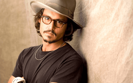 Johnny Depp posing in stylish square tortoise color glasses and hat 