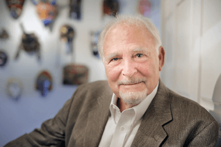 Older white man with goatee in suit jacket slightly smiling at the camera