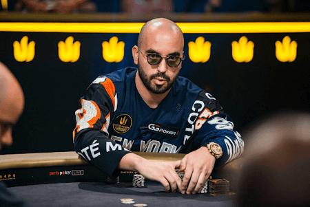 Professional poker player wearing aviator style rounded grey tinted glasses during a game