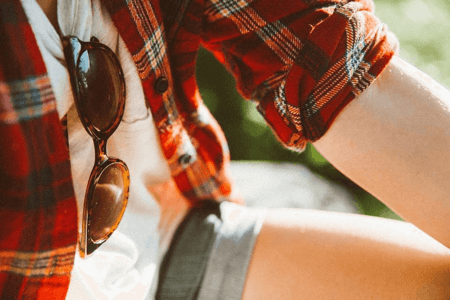 Classic rounded sunglasses hanging from front of t-shirt