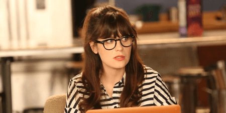 Zooey Deschanel wearing bold black keyhole glasses as her character Jess Day in New Girl