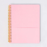 Open spiral notebook showing a pink pocket divider