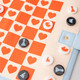 Checkered heart game board laid out with round plastic chess pieces on it