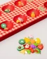 Close up of mancala pieces shaped like fruit