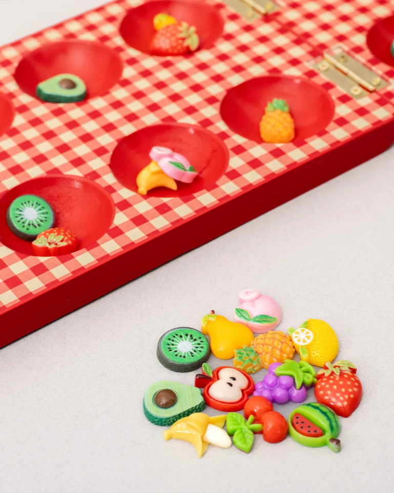 Close up of mancala pieces shaped like fruit