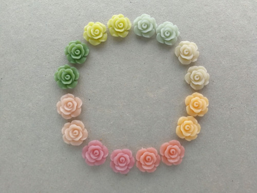 Resin flower cabochons in green, mint, peach, and pink.