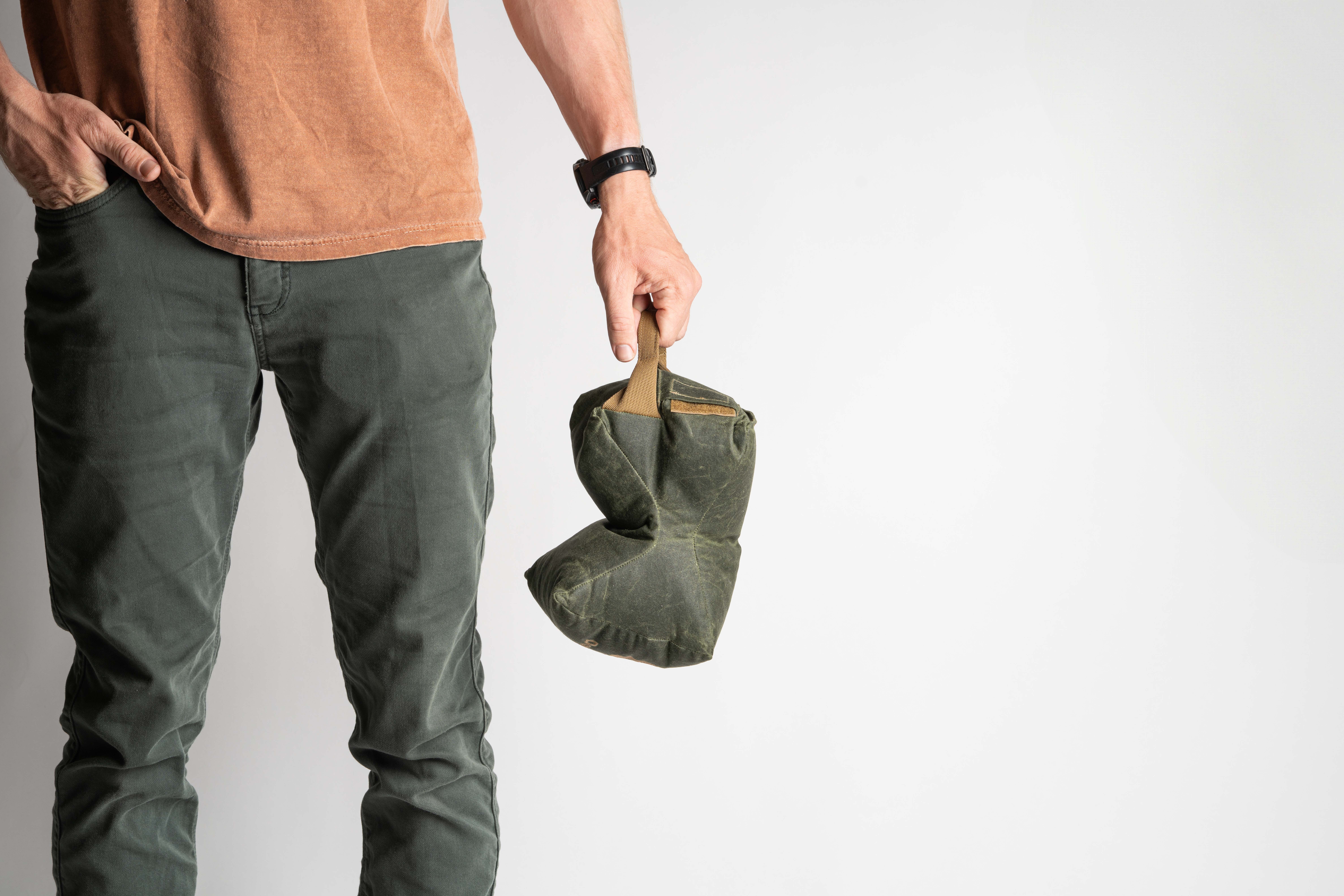 Man holding Game Changer bag at waist, white background