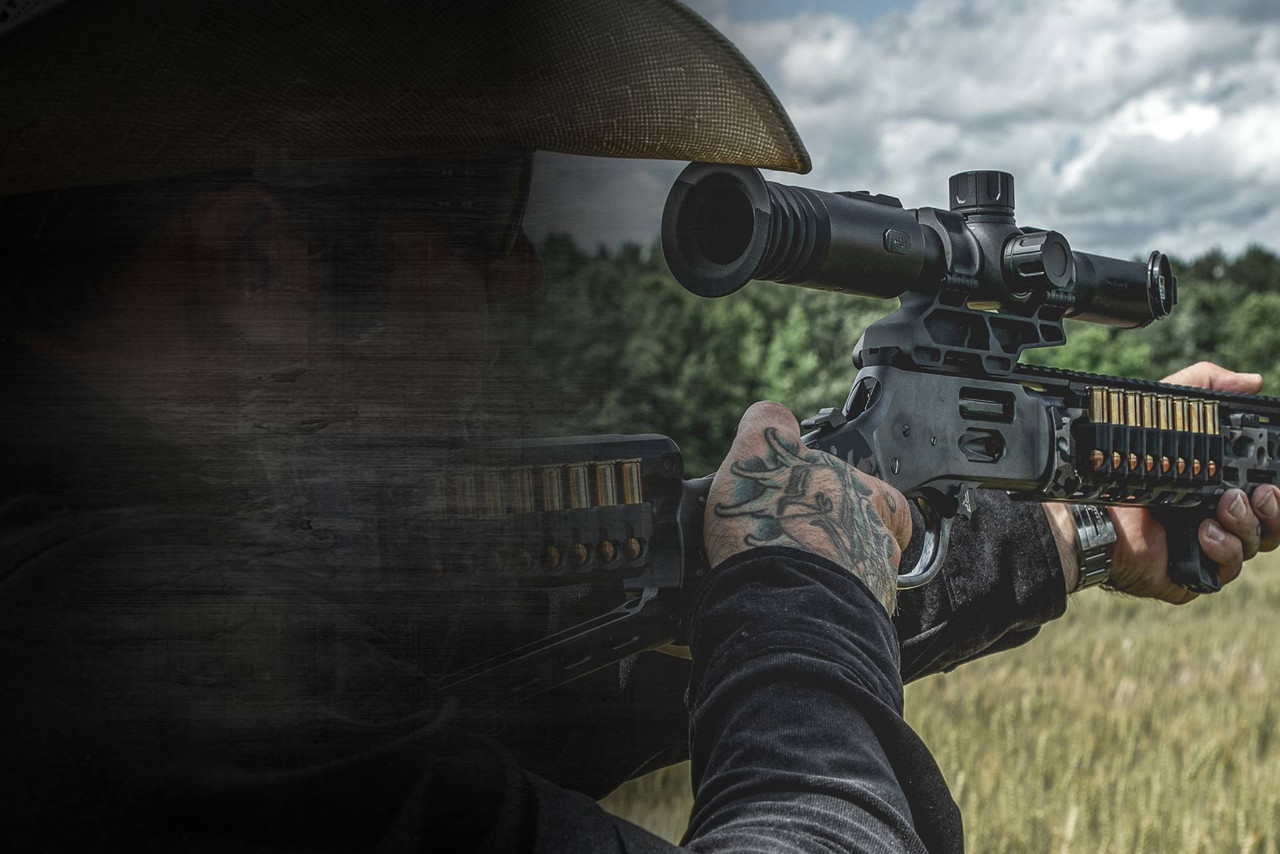 Shooter aiming a tactical rifle mounted with a thermal scope in an outdoor field.