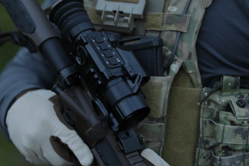 PARD SA32/62 LRF Thermal Imaging Scope displayed with hunting gear, showing rugged field-ready design.