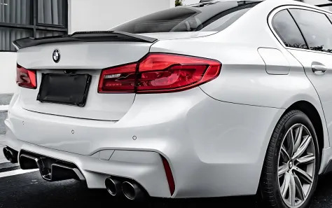 Rear of a white BMW F90 M5 showcasing its aerodynamic features.