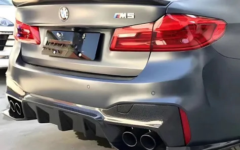 Rear view of a BMW F90 M5 with dual exhausts and sporty design.