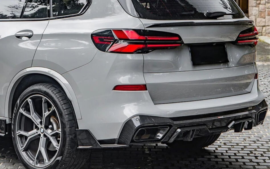 Rear view of a gray BMW SUV with sporty alloy wheels, dual exhaust, and modern LED taillights.