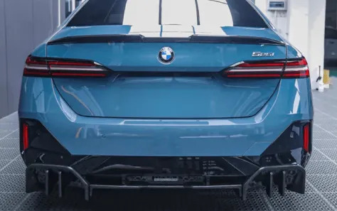Rear view of a blue BMW G60 with custom aftermarket parts.