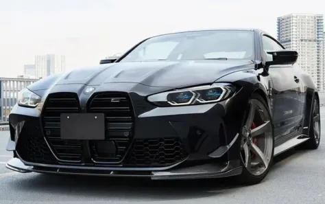 Front profile of a black BMW G83 with performance enhancements.