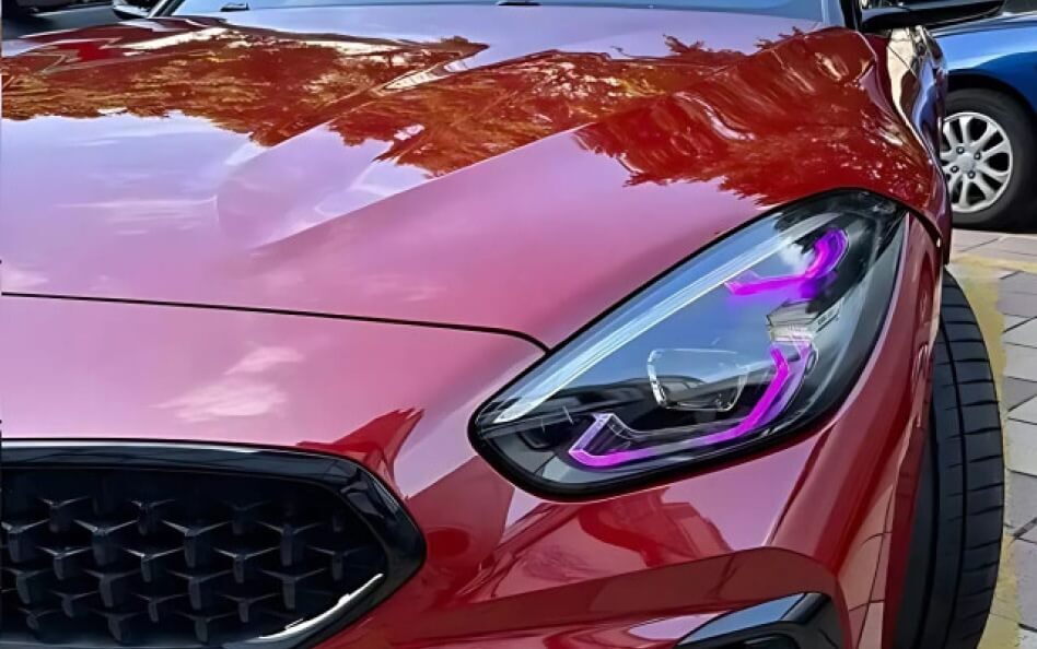Front view of a red BMW Z4 with aftermarket headlights.