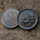 blackened bronze coin has a skull, the reverse has a vulture and inscribed Crom Counts the Dead in Icelandic Elder Futhark runes