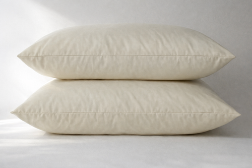 Pair of stacked Cozy Comfort Pillows in natural wheat colored cotton covers