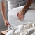 Person putting NoTuck Top Sheet® on bed