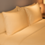 Pair of prairie gold New Adventures percale pillowcases on bed