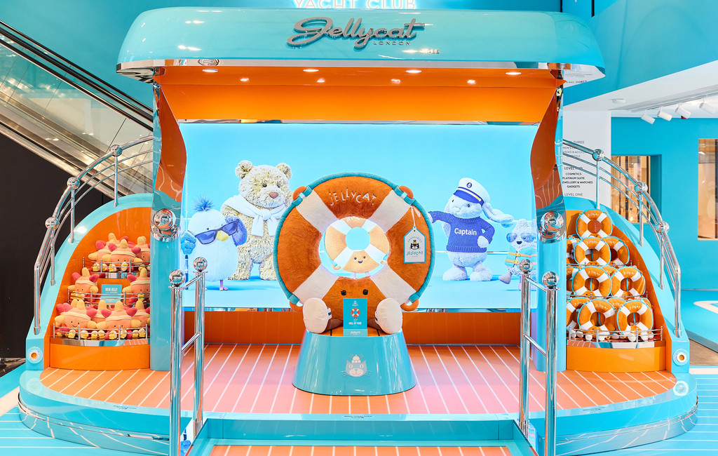 Jellycat Yacht Club display with plush characters and a large lifebuoy centerpiece in a bright turquoise retail space.