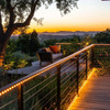 evening backyard setting, warm white rope lights coiled around a deck railing