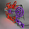 A neon sign glows against a gray background, displaying the phrase “Trick or Treat” in bright orange cursive. White, purple, and pink neon shapes surround the text, including a flower-like design, a spiral resembling a lollipop, and a wrapped candy.