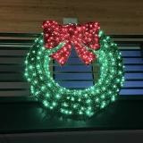 giant pre-lit LED Christmas wreath with bow on railing