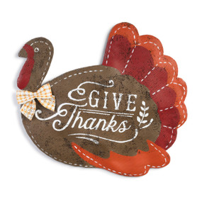 metal wall hanging painted and shaped like a turkey with Give Thanks painted in center in white