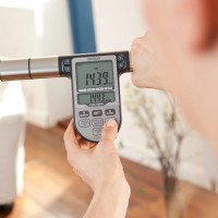 Person holding the Omron BF511 handheld unit while viewing measurement results such as calories and body fat percentage on the digital display.