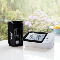 Omron M7 Intelli IT blood pressure monitor with IntelliWrap cuff placed on table in home setting