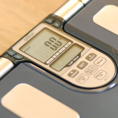 Close-up of the Omron BF511 display and control panel showing weight reading and user selection buttons.