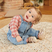 Baby girl sitting on a rug in Start-Rite Wiggle pale gold pre-walker shoes