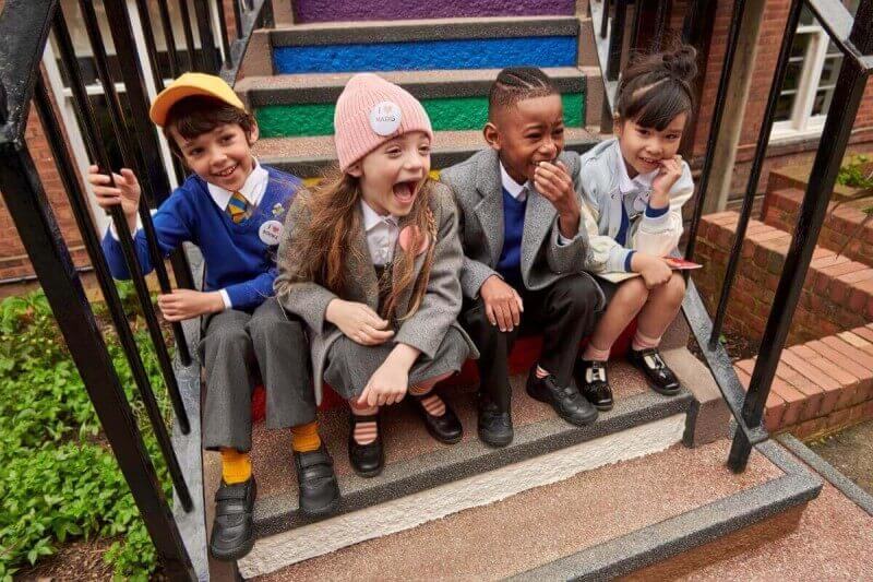 school children smiling and laughing on steps