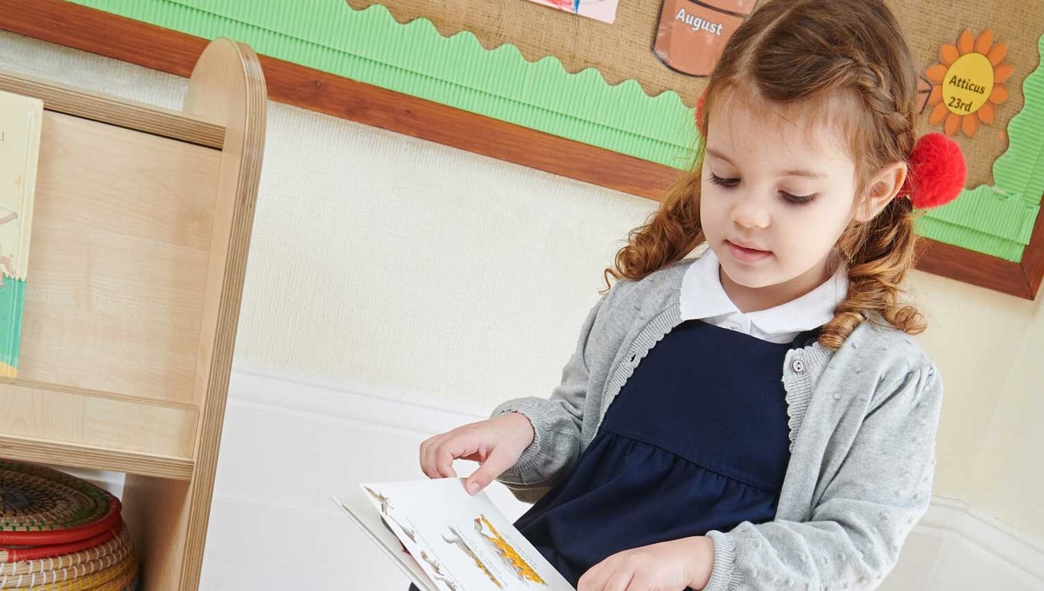 a girl sitting, reading a book