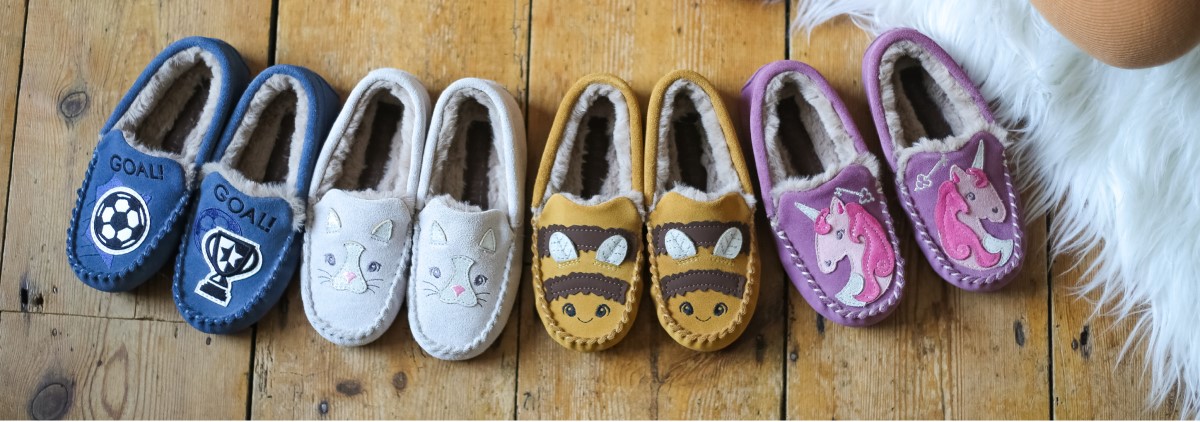 pairs of children's slippers on a wooden floor